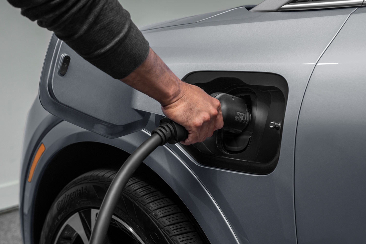 persona conectando el cargador eléctrico